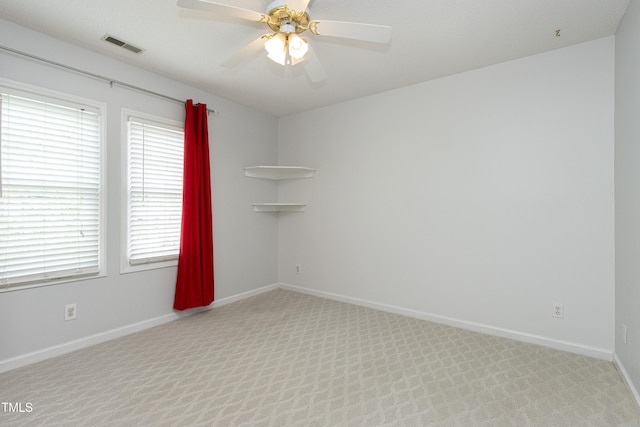 unfurnished room with baseboards, a ceiling fan, visible vents, and carpet flooring