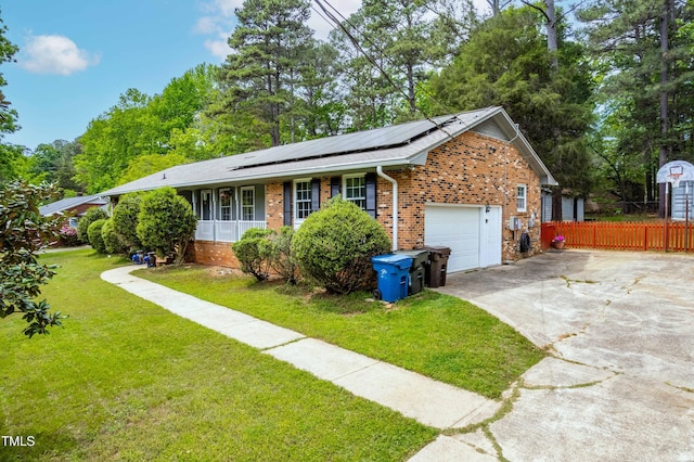 149 Baldwin Dr, Durham, NC 27712 - view of home's exterior featuring brick siding, a lawn, roof mounted solar panels, concrete driveway, and an attached garage
