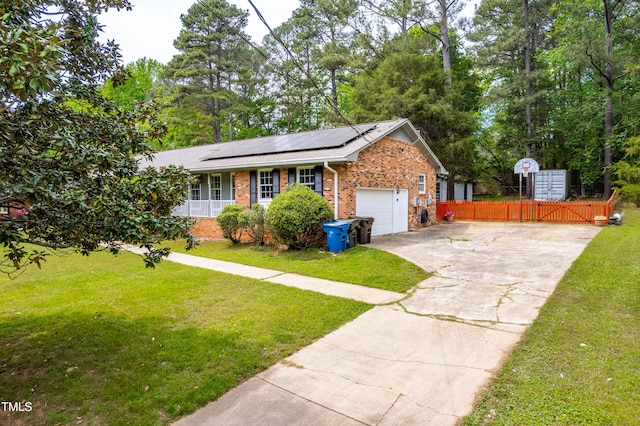 149 Baldwin Dr, Durham, NC 27712 - ranch-style home with fence, solar panels, a front lawn, and brick siding
