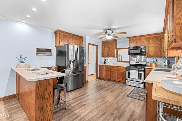 149 Baldwin Dr, Durham, NC 27712 - kitchen with crown molding, ceiling fan, appliances with stainless steel finishes, and light countertops
