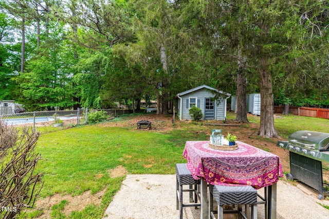 149 Baldwin Dr, Durham, NC 27712 - view of yard featuring an outdoor fire pit, a fenced backyard, an outbuilding, and a patio area