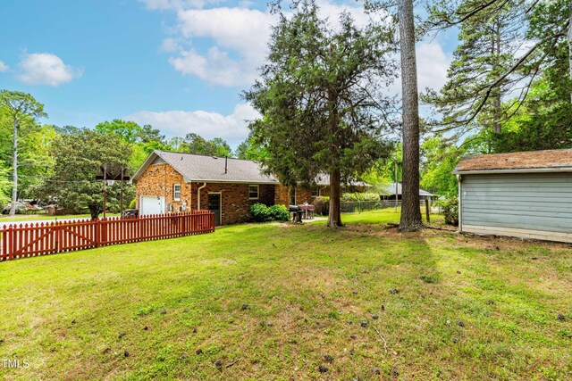 149 Baldwin Dr, Durham, NC 27712 - view of yard featuring an attached garage and a fenced backyard