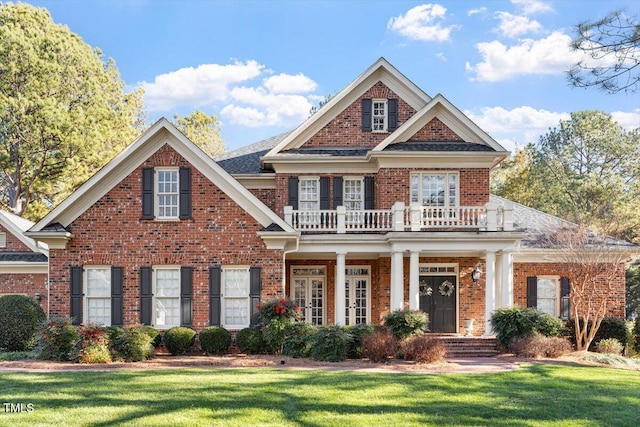 1317 Colonial Club Rd, Wake Forest, NC 27587 - georgian-style home featuring covered porch, a front yard, a balcony, and brick siding
