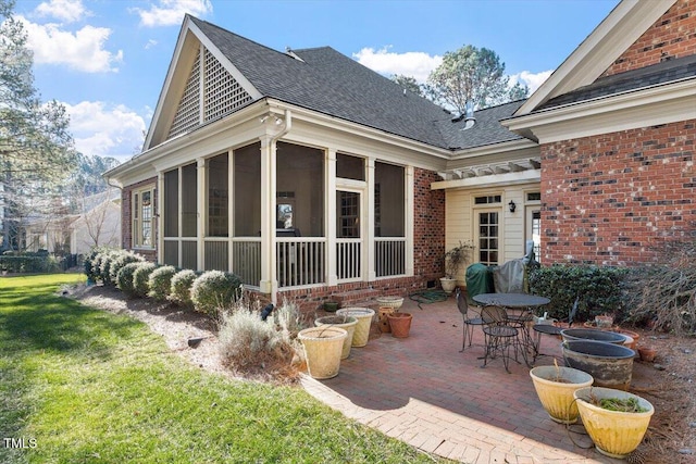 1317 Colonial Club Rd, Wake Forest, NC 27587 - back of property featuring a sunroom, a patio area, a lawn, brick siding, and roof with shingles