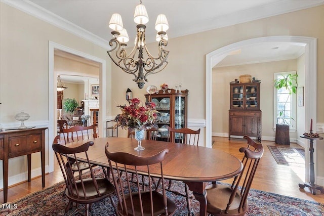1317 Colonial Club Rd, Wake Forest, NC 27587 - dining space with wood finished floors, arched walkways, a notable chandelier, and crown molding
