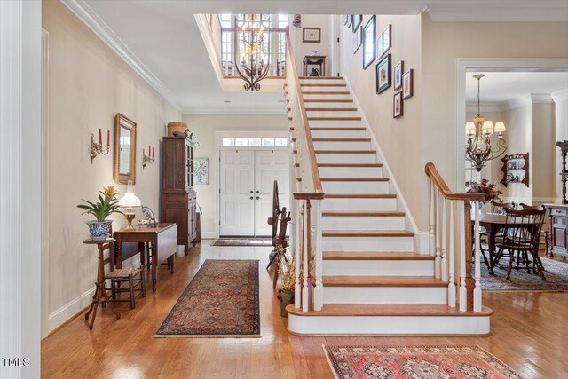1317 Colonial Club Rd, Wake Forest, NC 27587 - entrance foyer with stairs, wood finished floors, a chandelier, and ornamental molding