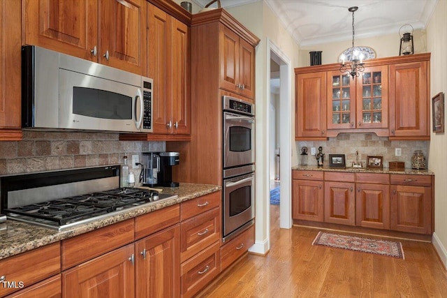 1317 Colonial Club Rd, Wake Forest, NC 27587 - kitchen featuring light stone counters, brown cabinetry, stainless steel appliances, backsplash, and light wood-type flooring