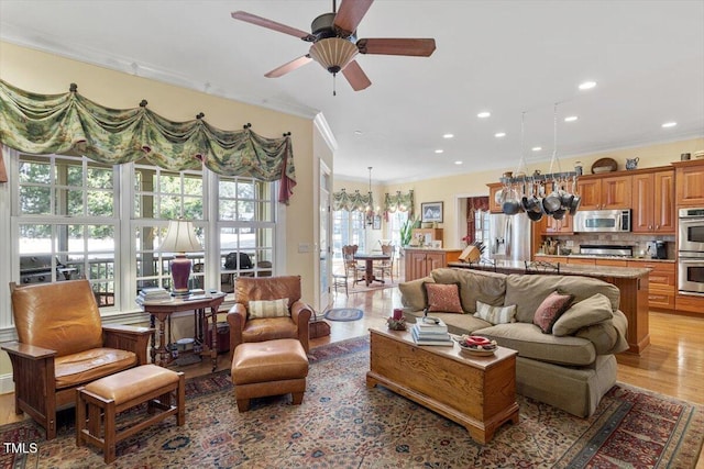 1317 Colonial Club Rd, Wake Forest, NC 27587 - living area with a wealth of natural light, crown molding, light wood finished floors, and ceiling fan with notable chandelier
