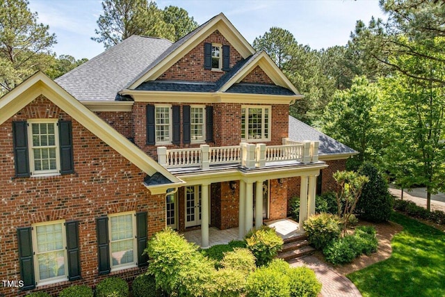 1317 Colonial Club Rd, Wake Forest, NC 27587 - craftsman house with brick siding, a porch, a balcony, and roof with shingles