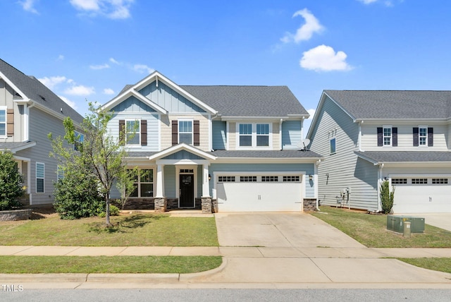craftsman-style home with board and batten siding, a front lawn, concrete driveway, and an attached garage