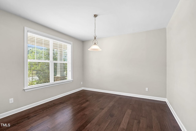 unfurnished room featuring dark wood-style floors and baseboards