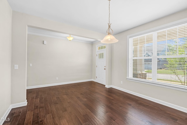 spare room featuring dark wood-style floors, baseboards, and a healthy amount of sunlight