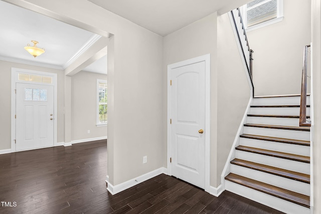 foyer featuring ornamental molding, dark wood-style floors, stairway, and baseboards