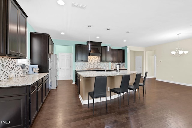 kitchen with visible vents, dark brown cabinets, a chandelier, and tasteful backsplash