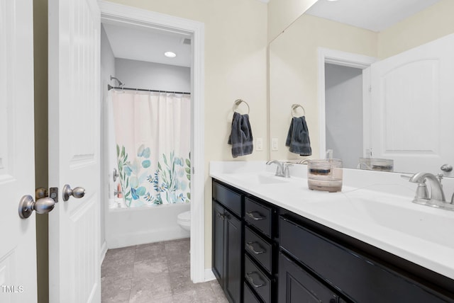 bathroom featuring double vanity, shower / tub combo, toilet, and a sink