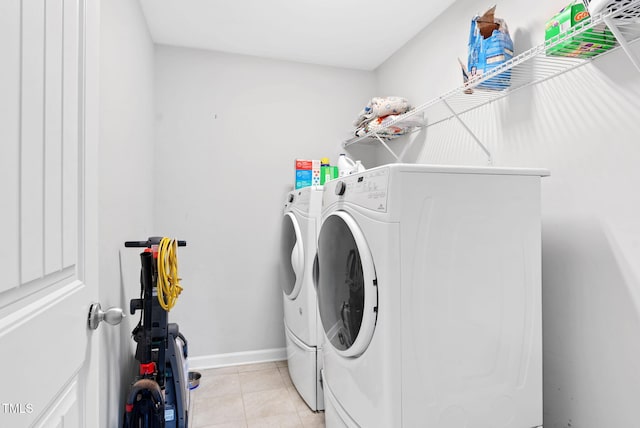 laundry room with light tile patterned floors, independent washer and dryer, laundry area, and baseboards