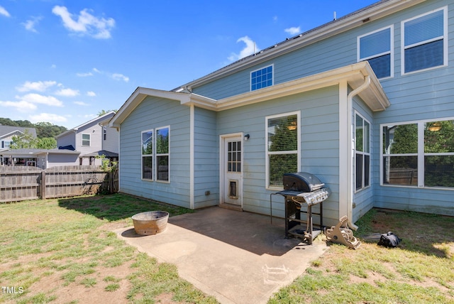 rear view of property featuring fence, a patio area, and a yard
