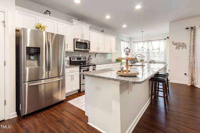 46 S Great White Way, Clayton, NC 27527 - kitchen with recessed lighting, stainless steel appliances, backsplash, a kitchen island with sink, and white cabinetry
