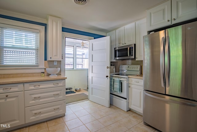 kitchen featuring light countertops, appliances with stainless steel finishes, backsplash, and visible vents