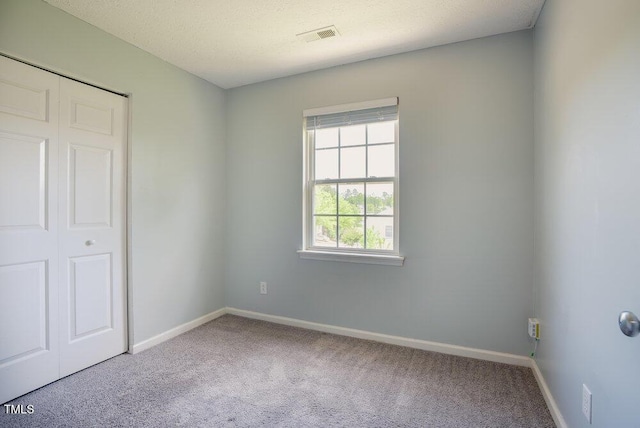 unfurnished bedroom featuring visible vents, baseboards, carpet flooring, and a closet