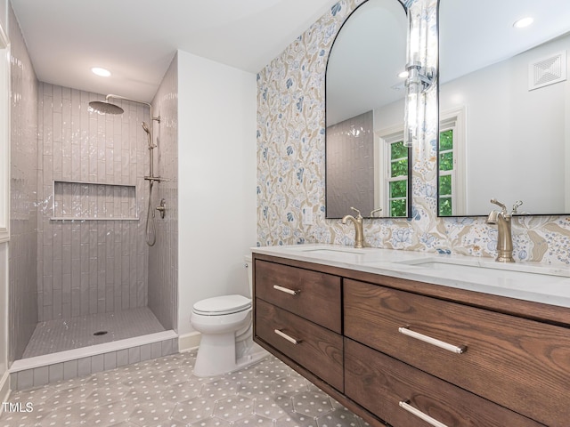 3009 Hillmer Dr, Raleigh, NC 27609 - full bathroom with a sink, double vanity, toilet, and a tile shower