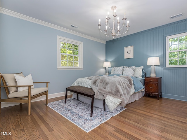 3009 Hillmer Dr, Raleigh, NC 27609 - bedroom featuring an inviting chandelier, wood finished floors, visible vents, and baseboards
