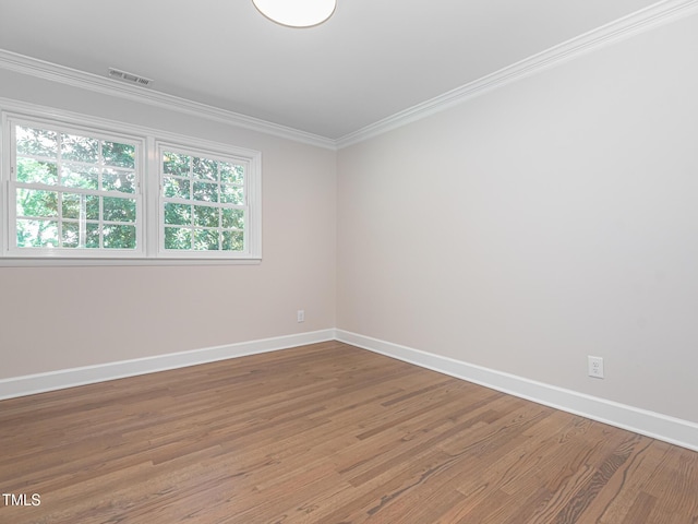 3009 Hillmer Dr, Raleigh, NC 27609 - spare room featuring crown molding, wood finished floors, visible vents, and baseboards