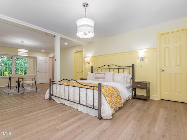 3009 Hillmer Dr, Raleigh, NC 27609 - bedroom featuring a wainscoted wall, wood finished floors, and baseboards