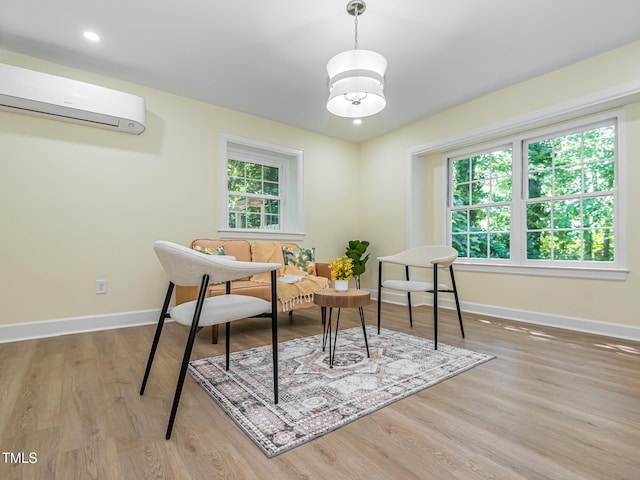 3009 Hillmer Dr, Raleigh, NC 27609 - sitting room featuring a wall mounted air conditioner, baseboards, and wood finished floors