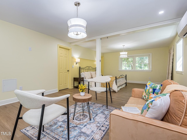 3009 Hillmer Dr, Raleigh, NC 27609 - living room featuring baseboards, a wall unit AC, and wood finished floors