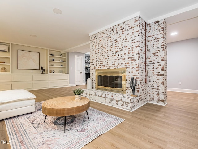 3009 Hillmer Dr, Raleigh, NC 27609 - living room featuring built in shelves, wood finished floors, baseboards, and a glass covered fireplace