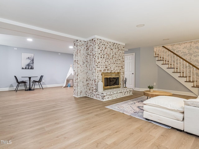 3009 Hillmer Dr, Raleigh, NC 27609 - living area with recessed lighting, baseboards, a glass covered fireplace, wood finished floors, and stairway