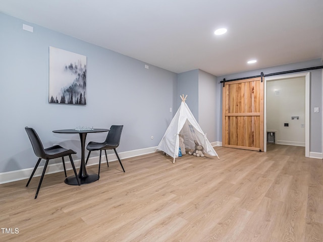 3009 Hillmer Dr, Raleigh, NC 27609 - playroom with a barn door, wood finished floors, baseboards, and recessed lighting