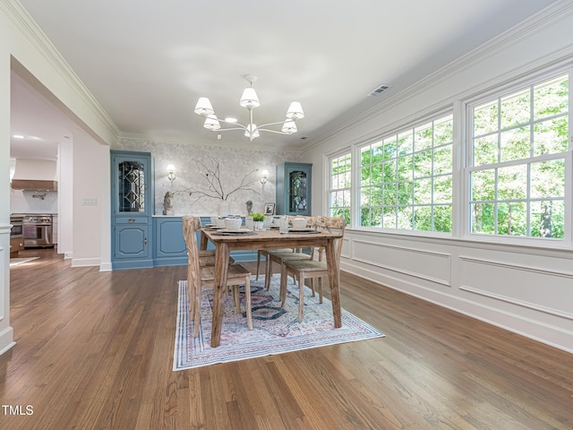 3009 Hillmer Dr, Raleigh, NC 27609 - dining room with a chandelier, ornamental molding, and wood finished floors