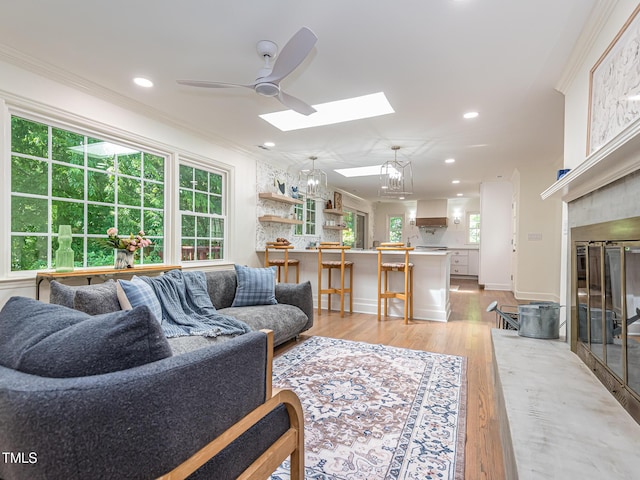 3009 Hillmer Dr, Raleigh, NC 27609 - living room featuring light wood-type flooring, a skylight, ornamental molding, and recessed lighting