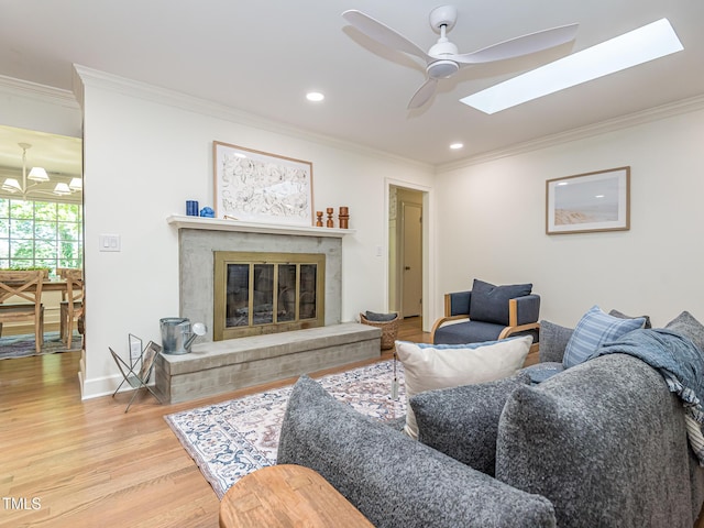 3009 Hillmer Dr, Raleigh, NC 27609 - living room featuring a skylight, a high end fireplace, wood finished floors, ornamental molding, and ceiling fan