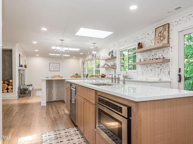 3009 Hillmer Dr, Raleigh, NC 27609 - kitchen featuring a sink, a skylight, visible vents, appliances with stainless steel finishes, and ornamental molding