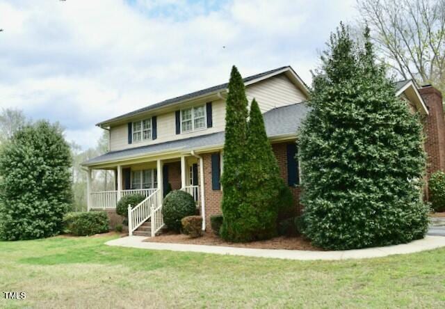 775 Sid Eaves Rd, Youngsville, NC 27596 - view of front of home featuring brick siding, a porch, and a front lawn