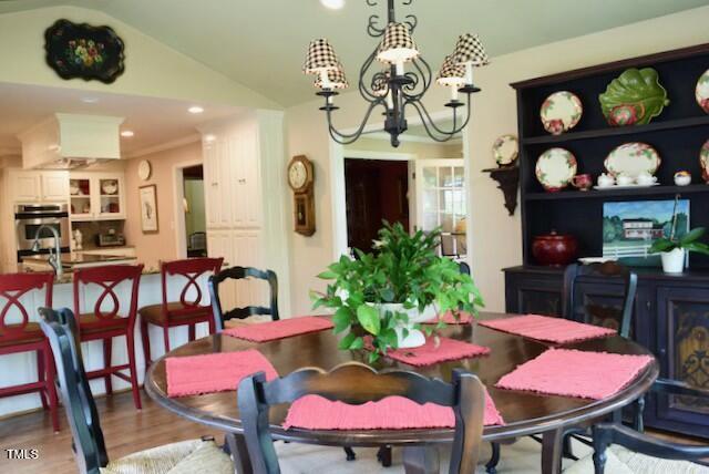 775 Sid Eaves Rd, Youngsville, NC 27596 - dining space with recessed lighting, lofted ceiling, light wood-style flooring, and a notable chandelier