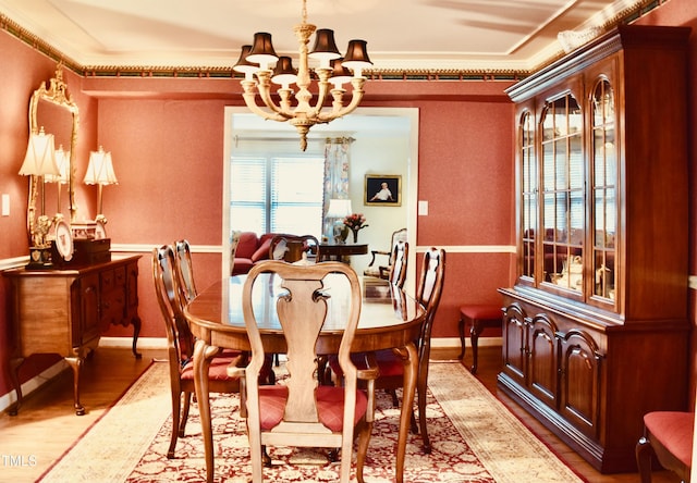 775 Sid Eaves Rd, Youngsville, NC 27596 - dining area with wood finished floors, a chandelier, crown molding, and baseboards