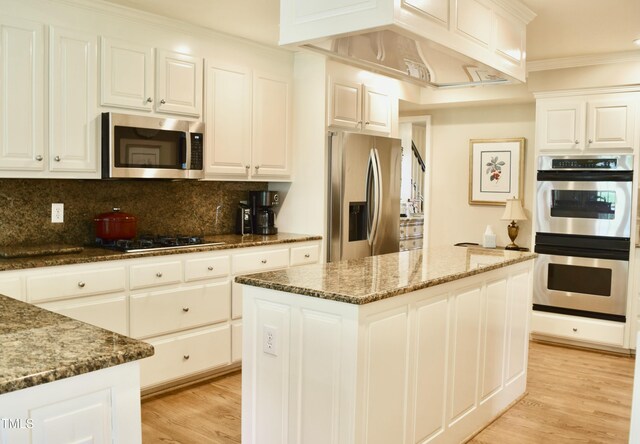 775 Sid Eaves Rd, Youngsville, NC 27596 - kitchen with backsplash, light wood-style flooring, stainless steel appliances, and white cabinetry