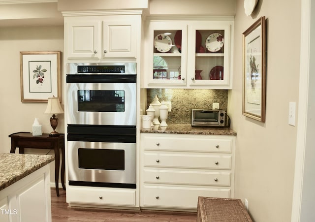 775 Sid Eaves Rd, Youngsville, NC 27596 - kitchen with double oven, stone counters, glass insert cabinets, and backsplash