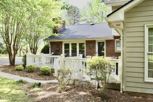 775 Sid Eaves Rd, Youngsville, NC 27596 - rear view of property with a chimney, brick siding, a shingled roof, and a wooden deck