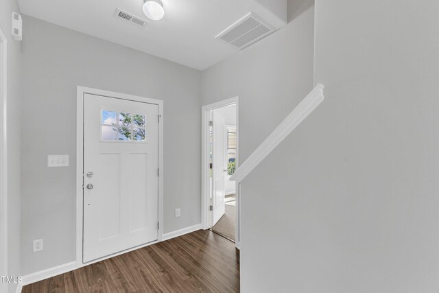 entryway with baseboards, visible vents, and dark wood-type flooring