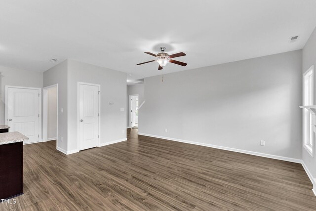 unfurnished living room with a ceiling fan, baseboards, visible vents, and dark wood-type flooring