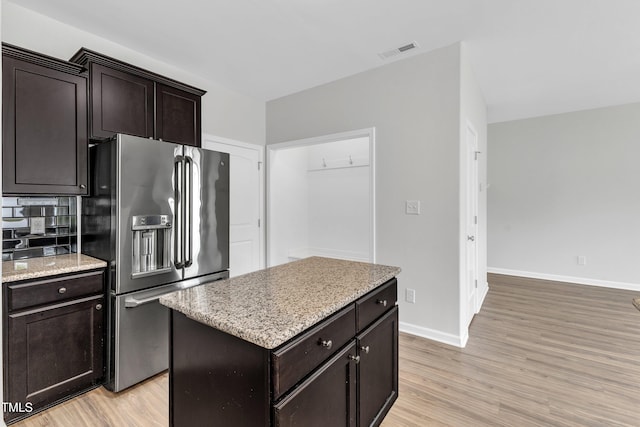 kitchen featuring visible vents, light wood-style floors, baseboards, and stainless steel fridge with ice dispenser