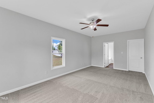 carpeted empty room with ceiling fan and baseboards