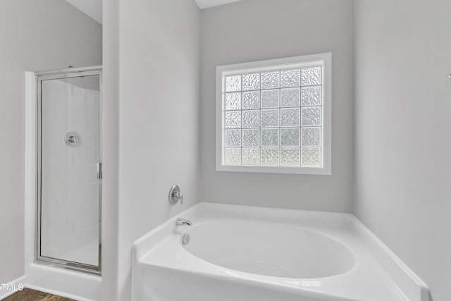 full bathroom featuring a garden tub and a stall shower