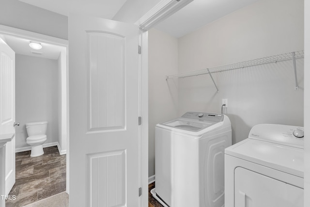 clothes washing area featuring separate washer and dryer and laundry area