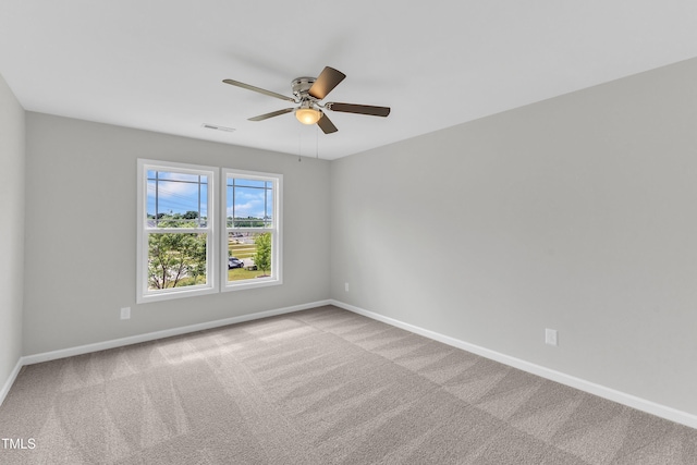 carpeted spare room featuring a ceiling fan, baseboards, and visible vents